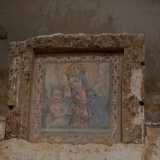 La Vergine, avvolta da un mantello azzurro, indossa una corona dorata e sorveglia con sguardo amorevole il messia, il quale tra le mani coccola un cardellino
